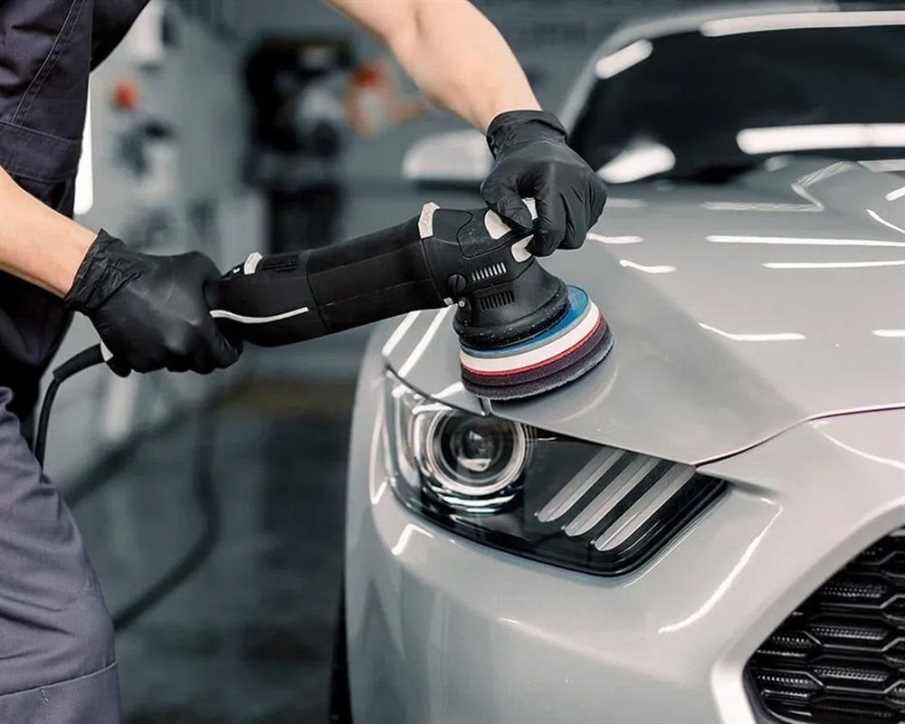 Gentech technician machine-polishing a car's paintwork